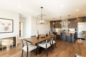 A modern kitchen with wooden cabinets, a central island, and pendant lighting.