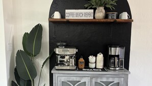 Un angolo caffè con una macchina per espresso Breville, un macinacaffè, un montalatte e una caffettiera.