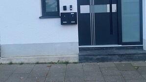 Un edificio moderno con una puerta negra marcada 