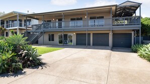 A modern multi-story building with a covered balcony, a garage, and a well-maintained lawn. - Spacious 3-bed Ground Level Beachside Stay (Middleton)
