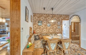 Un rincón comedor acogedor con una mesa de madera, sillas y un banco.