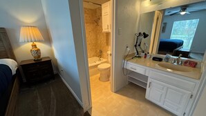 Ein Hotelbad mit Badewanne, Toilette, Waschbecken und Spiegel.