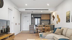 Een moderne woonkamer met een hoekbank, een salontafel en een flatscreen televisie.