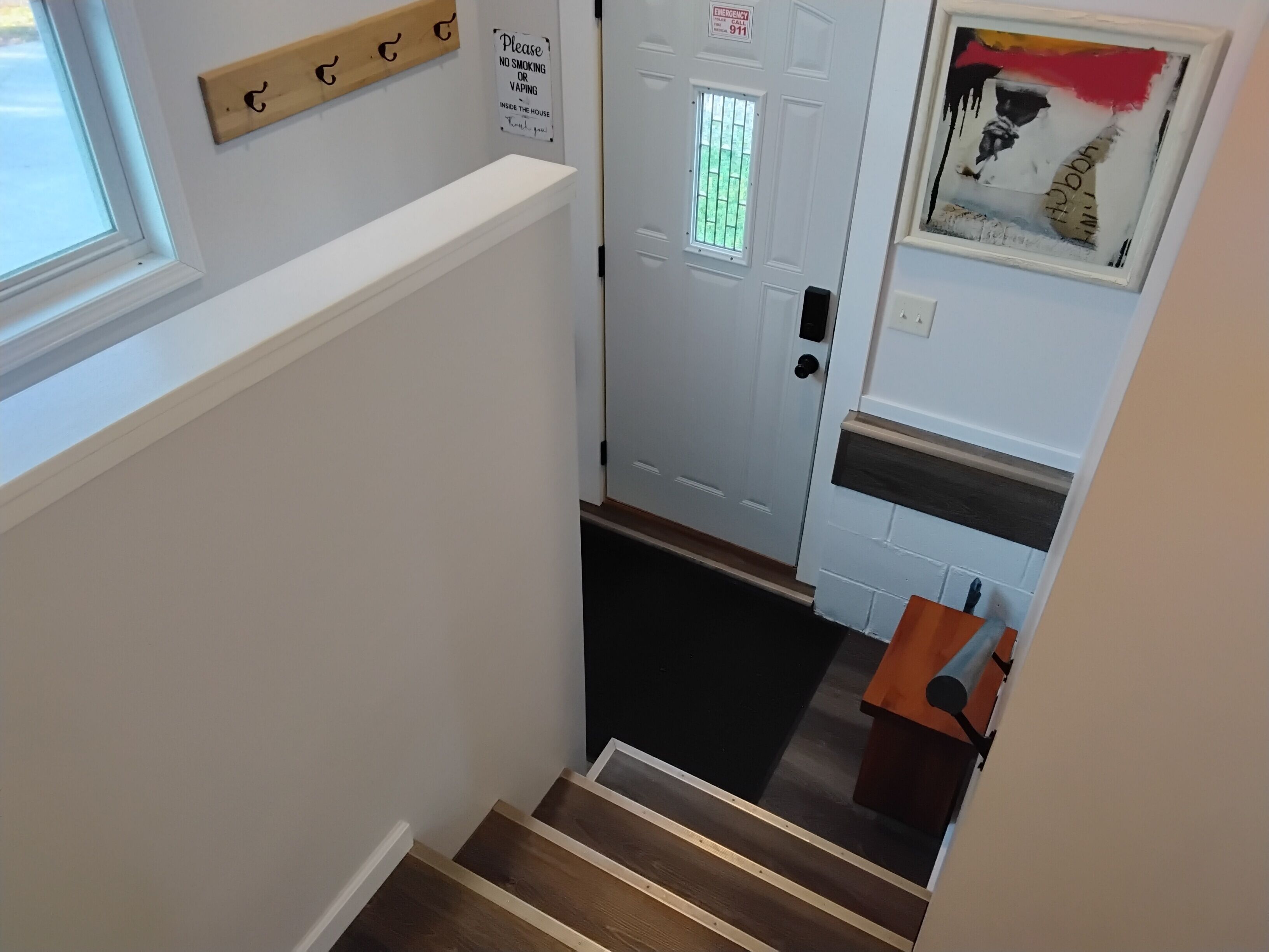 A staircase leading to a room with a door marked 'Emergency Exit' and a 'No Smoking' sign.