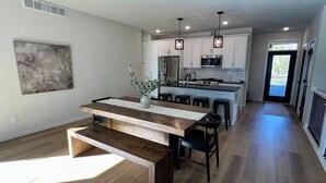 A modern kitchen with a central island, white cabinets, and pendant lighting. - Villa 1 on Preserve Golf Course! (Pequot Lakes)