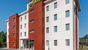A B&B hotel with a red and white facade, a prominent sign, and a modern design. - B&B Hotel Bordeaux Sud Mios (Mios)
