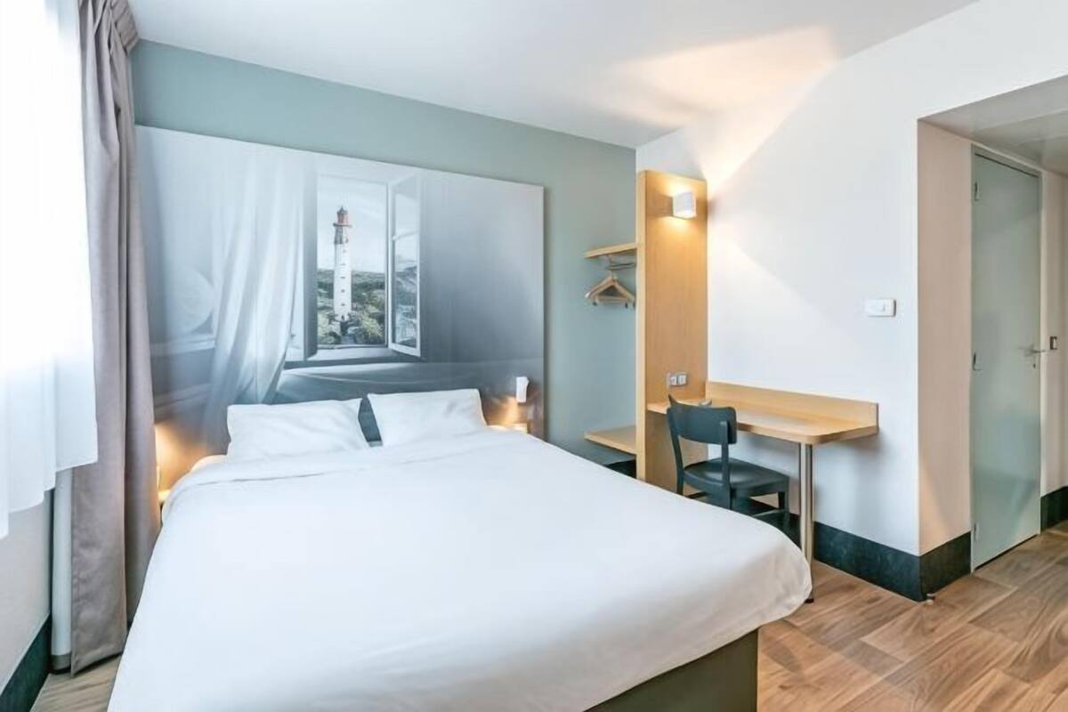 Een hotelkamer met een bed, een bureau en een stoel.