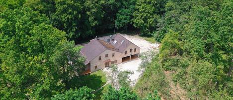 A single-story building with a sloped roof, surrounded by dense forest.
