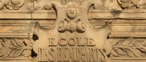 A stone plaque with the inscription "ECOLE DES BEAUX-ARTS".