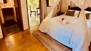 A bedroom with a bed, a bedside table, and a window. - Big Bambu (Porto Seguro)