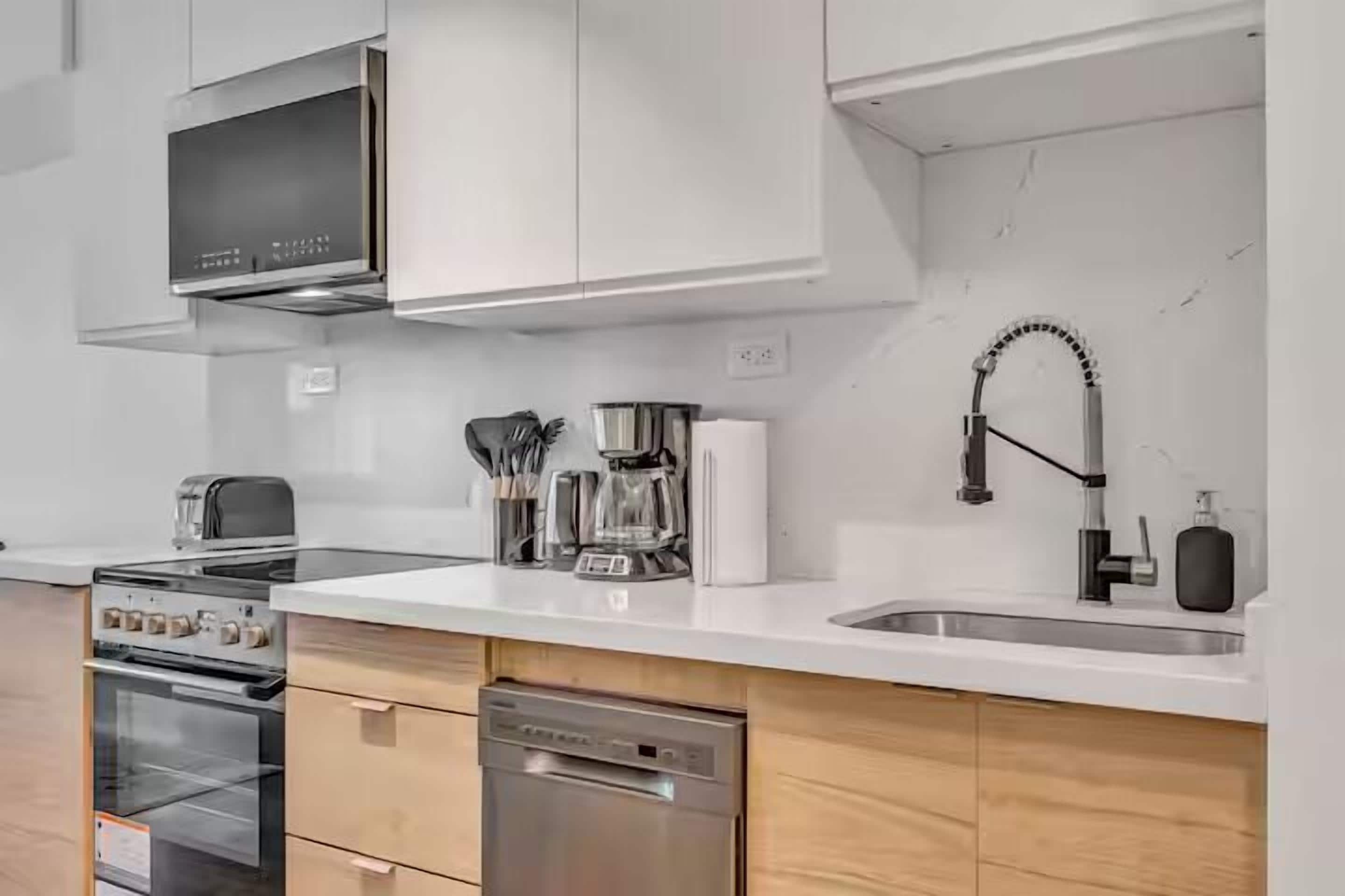 A modern kitchen with stainless steel appliances, a dishwasher, and a sink.