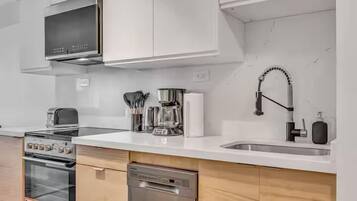 A modern kitchen with stainless steel appliances, a dishwasher, and a sink.