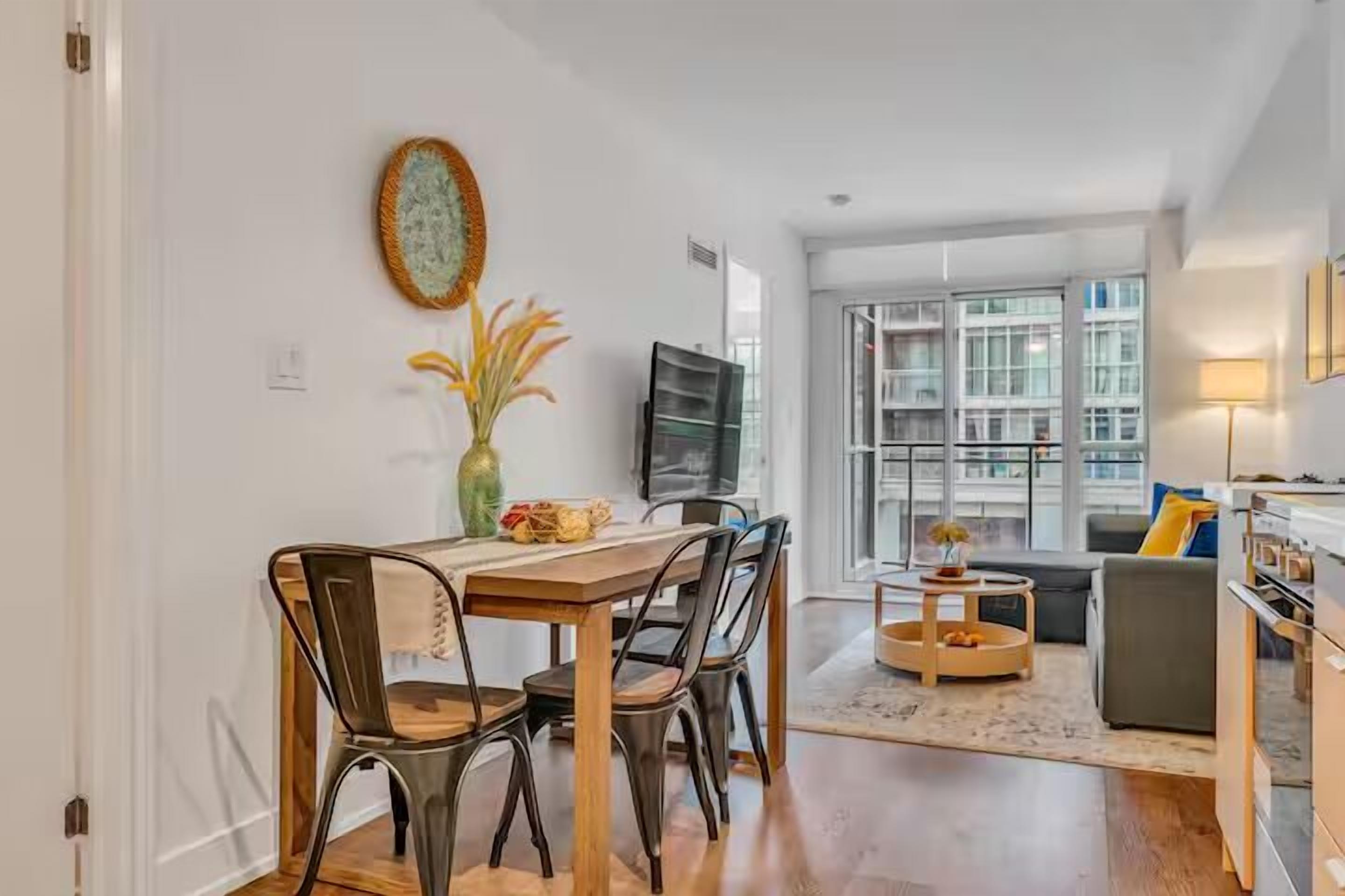 Una sala de estar moderna con comedor, ventanas amplias y vistas a la ciudad.