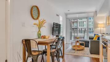 Una sala de estar moderna con comedor, ventanas amplias y vistas a la ciudad.