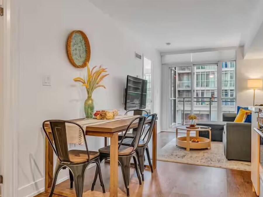 Una sala de estar moderna con comedor, ventanas amplias y vistas a la ciudad.