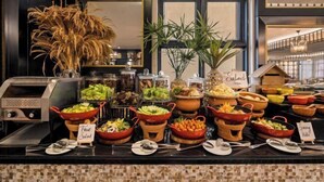 Een buffet met diverse gerechten, waaronder salades, fruit en groenten.