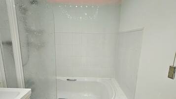 A bathroom with a shower, a bathtub, and a toilet.
