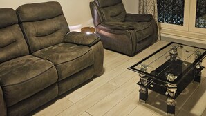 Una sala de estar con sofá, sillón y mesa de centro.