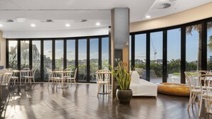 A spacious indoor area with a large window offering a view of the cityscape. - City Escape With Balcony & Resort-style Amenities (Brisbane)