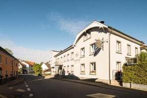 A building with a sign reading 'KRONE' on the facade, a clear sky, and a street in front. - Genusshotel Krone & Roadtrips bei Basel (Inzlingen)