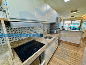 A modern kitchen with a built-in stovetop, stainless steel appliances, and patterned backsplash. - Luxury Foot in the Sand at La Fleur Polynesia (Porto de Galinhas)