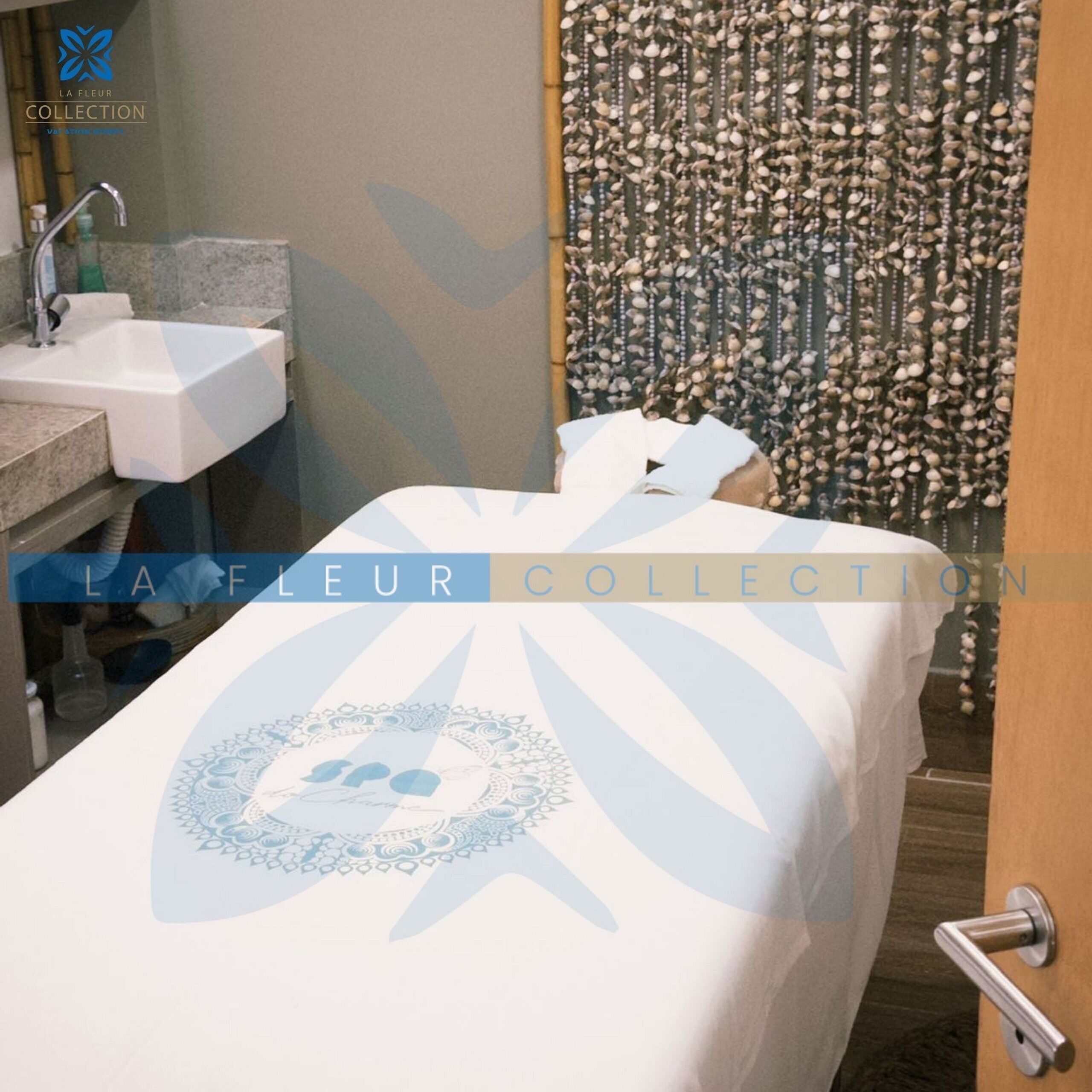 A spa room with a treatment bed, a sink, and a decorative wall with shells.