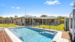 A swimming pool with a wooden deck, a covered patio area, and a fenced yard. - Family-friendly Home With Private Pool and BBQ (Sunshine Coast)