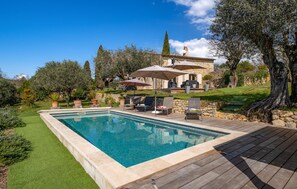 A swimming pool with a wooden deck, outdoor seating, and a stone house with a garden. - Beautiful home in Callian (Callian)
