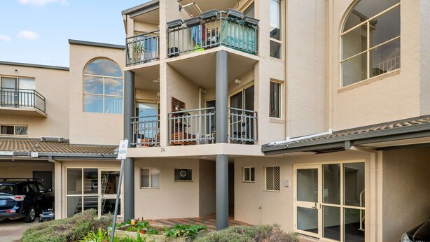 A multi-story residential building with balconies, large windows, and a garage. - Stylish 1-bed Stay With Balcony & Study (Canberra)