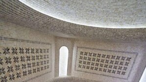 Una habitació amb sostre corbat, parets amb dibuixos i una columna central.