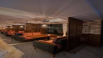 A modern lounge area with seating arrangements and a wooden partition.