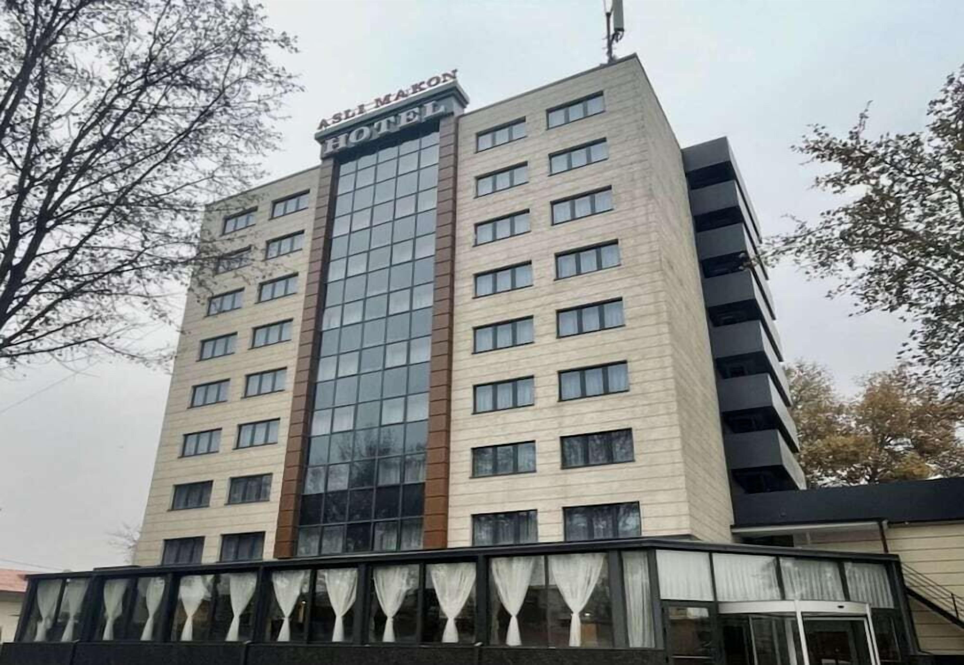 A multi-story hotel building with a prominent glass facade and a sign reading 'HOTEL'.