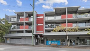 A multi-story building with a MyCare sign, indicating a medical facility. It features a modern architectural design with balconies and a clear sky. - Central Bowen Hills Stay (Brisbane)