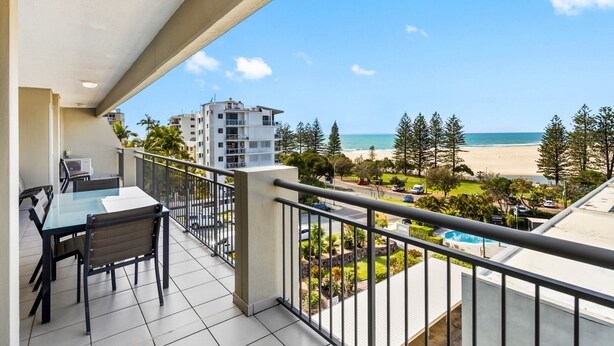 A balcony with a table and chairs, overlooking a beach and a pool. - Oceanfront 3-bed Retreat With Pool-steps to Beach (Sunshine Coast)