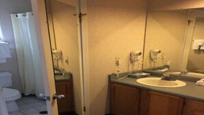Een badkamer met toilet, wastafel en spiegel.