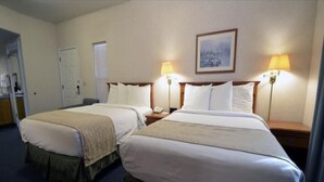 Een hotelkamer met twee bedden, een bureau, een stoel en twee bedlampjes.