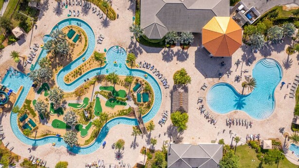 An aerial view of a resort with multiple swimming pools, sun loungers, and a large umbrella. - DisneyVilla 6 BD, Club/Water Park/Pool/Spa and BBQ (Kissimmee)