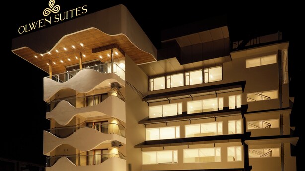 Un hotel moderno con numerosi balconi e un design architettonico originale a forma ondulata.