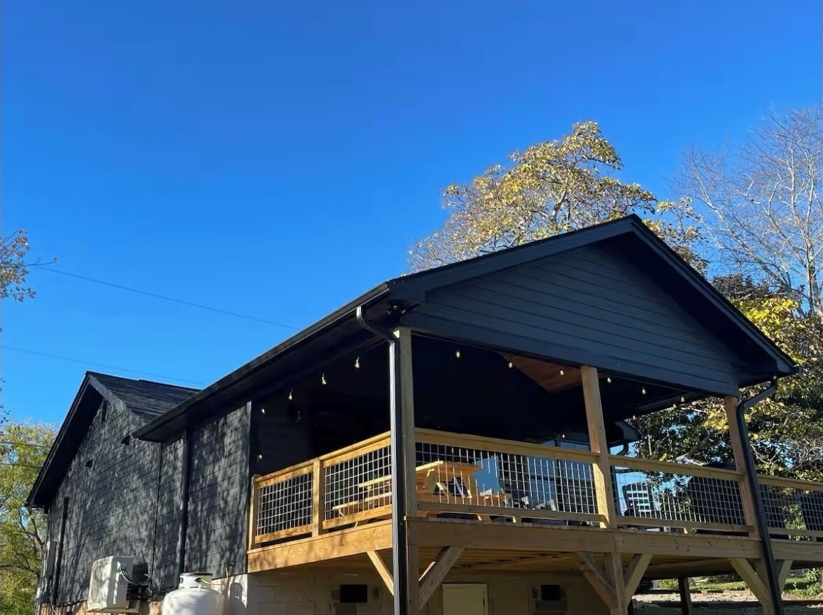 A two-story wooden building with a balcony and a covered porch area.