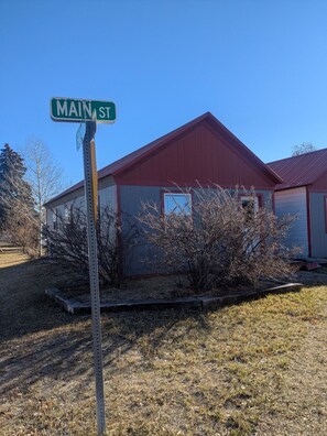 A building with a red roof and a sign indicating 'MAIN ST'. - Cozy 1-bedroom railroad house (Lima)