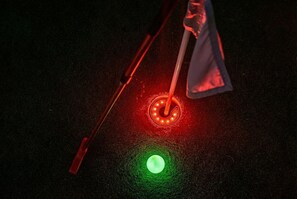 A close-up of a red and green illuminated object, possibly a part of a game or interactive display.