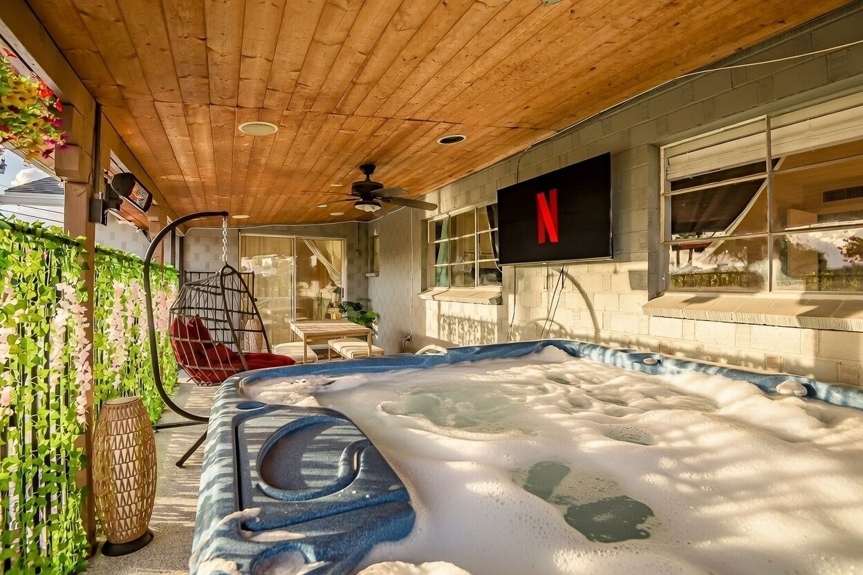 A hot tub with a wooden ceiling and a Netflix sign on the wall.
