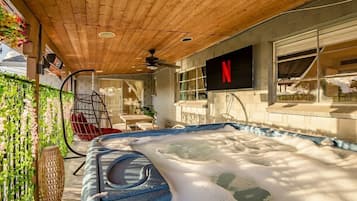A hot tub with a wooden ceiling and a Netflix sign on the wall.