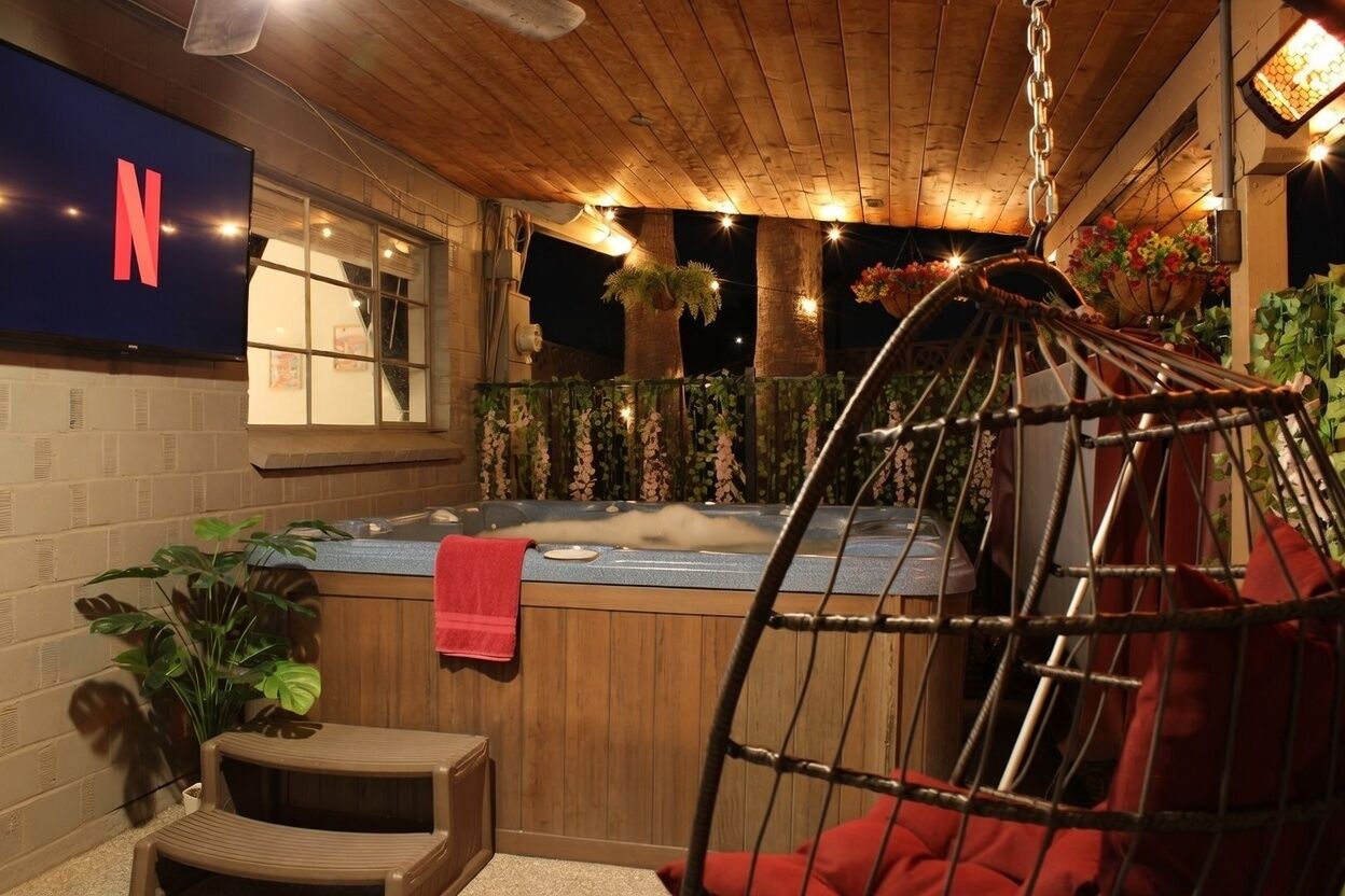 Un ambiente interno accogliente con una vasca idromassaggio, una sedia sospesa e il logo Netflix.