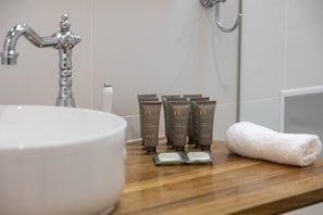 A bathroom sink, a wooden vanity, and a towel on the counter. - Bluestone Symmetrical Cottage With Outdoor Area (Adelaide)