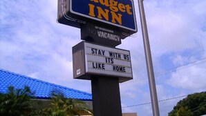 A Budget Inn sign with a vacancy notice and a slogan. - Budget inn (Okeechobee)
