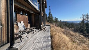 A wooden deck with lounge chairs overlooking a forested landscape. - Stunning home in Noresund with sauna (Noresund)