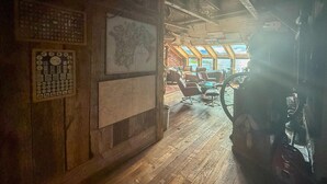 Un interior de madera con un mapa, un globo terráqueo y un volante.