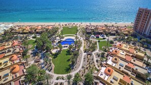 Un complex turístic amb piscina, platja i vista a l'oceà.