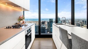 Una cocina moderna con vistas a la ciudad, un ventanal grande y un horno empotrado.